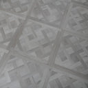 Silver grey SPC vinyl floor panel featuring light parquet herringbone design