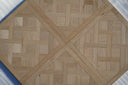 Light oak parquet wood panel with geometric herringbone cross pattern