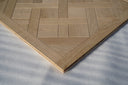Light oak parquet wood panel corner detail with herringbone pattern