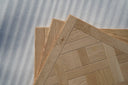 Light oak parquet wood panel set with herringbone pattern, matt lacquer finish