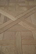 Light oak parquet wood panel with herringbone cross layout and visible wood grain