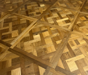 Smoked brushed wood Versailles parquet panel in warm honey tones with diagonal cross lines