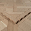 Unfinished wood parquet panel corner with stacked edges and visible tongue-and-groove