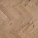 Light natural oak engineered herringbone wood flooring close-up with diagonal plank layout