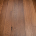 Smoked oak SPC click flooring showing wide plank seams and natural grain