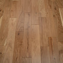 Engineered warm oak-toned wood flooring planks showing knots and grain