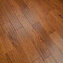 Golden hand-scraped engineered wood floor with visible grain on long planks.