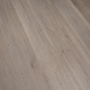 Wood-look vinyl plank flooring close-up, light gray-beige wood grain