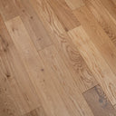 Natural light brown wood floor planks showing knots and swirling grain texture