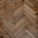 Engineered herringbone wood flooring with smoked light-brown planks and varied grain