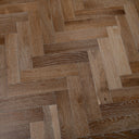 Engineered herringbone wood flooring with smoked light-brown boards and prominent texture