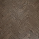 Engineered herringbone wood flooring in gunmetal grey with visible wood grain, close-up