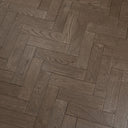 Engineered herringbone wood flooring in gunmetal grey, angled plank pattern close-up