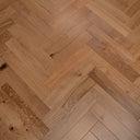 Engineered herringbone wood flooring close-up showing alternating oak plank widths