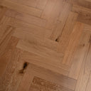 Engineered herringbone wood flooring close-up with natural knots and linear grain