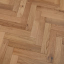 Engineered wood parquet flooring with herringbone pattern, light oak planks and knots.