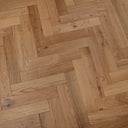 Light oak engineered wood herringbone flooring with brushed, oiled surface detail.