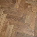 Smoked engineered wood flooring boards in herringbone layout, tan to medium brown