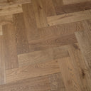 Engineered herringbone wood flooring in smoked brown tones, staggered plank lengths