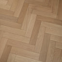Natural-toned herringbone engineered wood floor, long rectangular planks in repeating pattern.