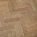 Light tan herringbone wood flooring with smooth boards and alternating plank layout.