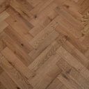 Brushed UV-oiled engineered wood herringbone parquet in warm tan with natural grain