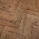 Engineered wood herringbone floor in light brown with long plank grain and knots