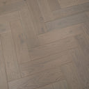 Engineered herringbone flooring detail, light grey brushed wood-look planks