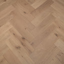 Engineered herringbone wood flooring in pale oak with visible knots and plank grain