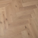 Light natural oak engineered herringbone wood flooring close-up with textured grain