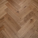 Engineered herringbone wood flooring in warm brushed oak, staggered plank pattern