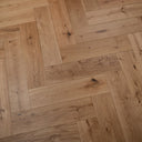 Engineered herringbone wood flooring in pale brushed oak, interlocking planks and grain