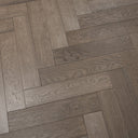 Gunmetal grey herringbone engineered wood flooring with visible woodgrain plank seams