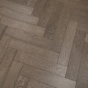 Gunmetal grey herringbone engineered wood flooring close-up of staggered plank joints