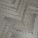 Pearl grey herringbone vinyl flooring close-up of plank texture and light knots