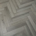 Pearl grey herringbone vinyl flooring with staggered rectangular planks and woodgrain lines