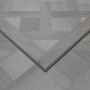 Silver grey SPC vinyl floor panel with beveled edges and parquet herringbone pattern