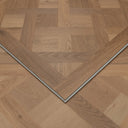 Natural wood-look SPC flooring panel corner with beveled edges and silver trim