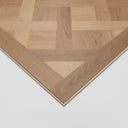 Natural wood-look SPC flooring panel corner with beveled edge and silver border