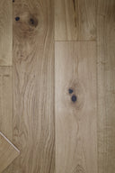 Natural oak engineered wood flooring planks with dark knots and straight seams.