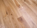 Lacquered solid wood plank flooring in light oak tone with visible knots