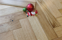 Engineered herringbone wood flooring, warm light oak tone, rectangular planks