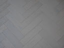 White brushed matte engineered wood herringbone flooring with diagonal plank layout