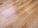Lacquered solid wood plank flooring in light oak tone, straight plank lines and knots