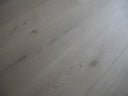 Light engineered wood floor planks in wide view, smooth finish with subtle seams
