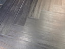 Gray wood-look vinyl flooring planks in herringbone pattern
