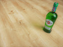 Natural oak WPC flooring planks close-up with built-in underlay and bottle on floor