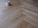 Smoked white engineered herringbone wood floor detail with realistic wood grain