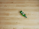 Natural oak WPC flooring planks with built-in underlay, bottle placed on surface