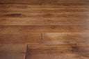 Engineered wood flooring close-up: medium-brown planks with visible seams and grain
